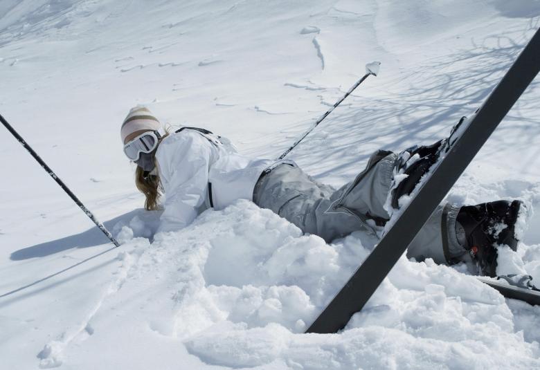 Woman fall down while skiing