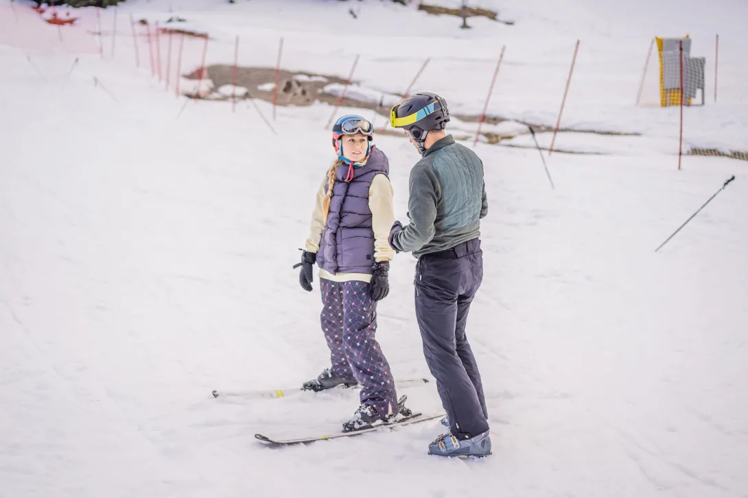 Woman learning to ski with instructor