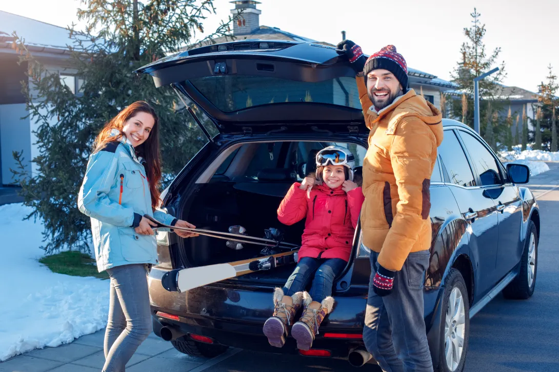 Family with ski equipment in car