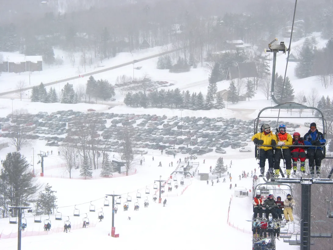 Snow falling while people on a ski lift